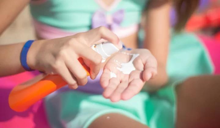 女孩户外挤出防晒喷雾涂抹手上