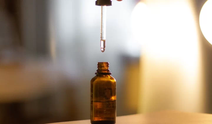 琥珀色滴管精华瓶,温暖灯光背景