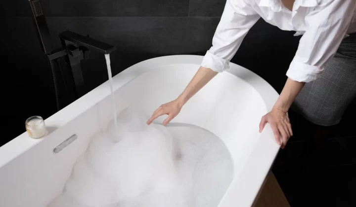 女性在浴室为泡泡浴放水