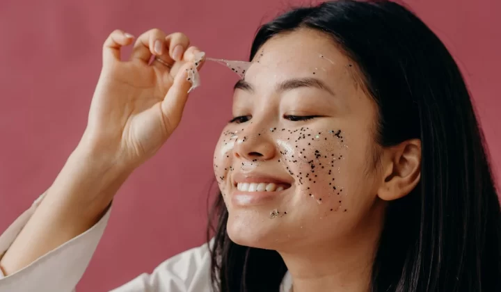 亚洲女性微笑撕下闪亮面膜