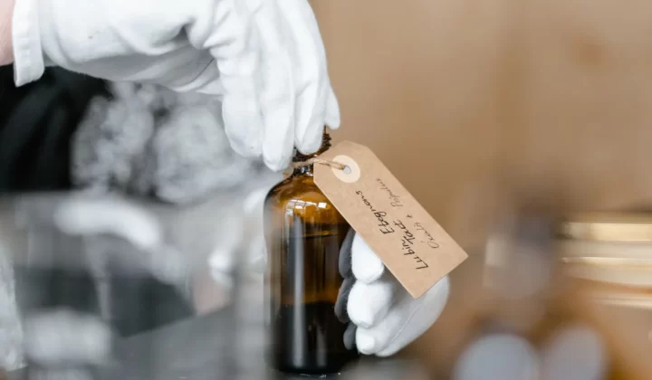 戴手套的手拿着带手写标签的玻璃瓶