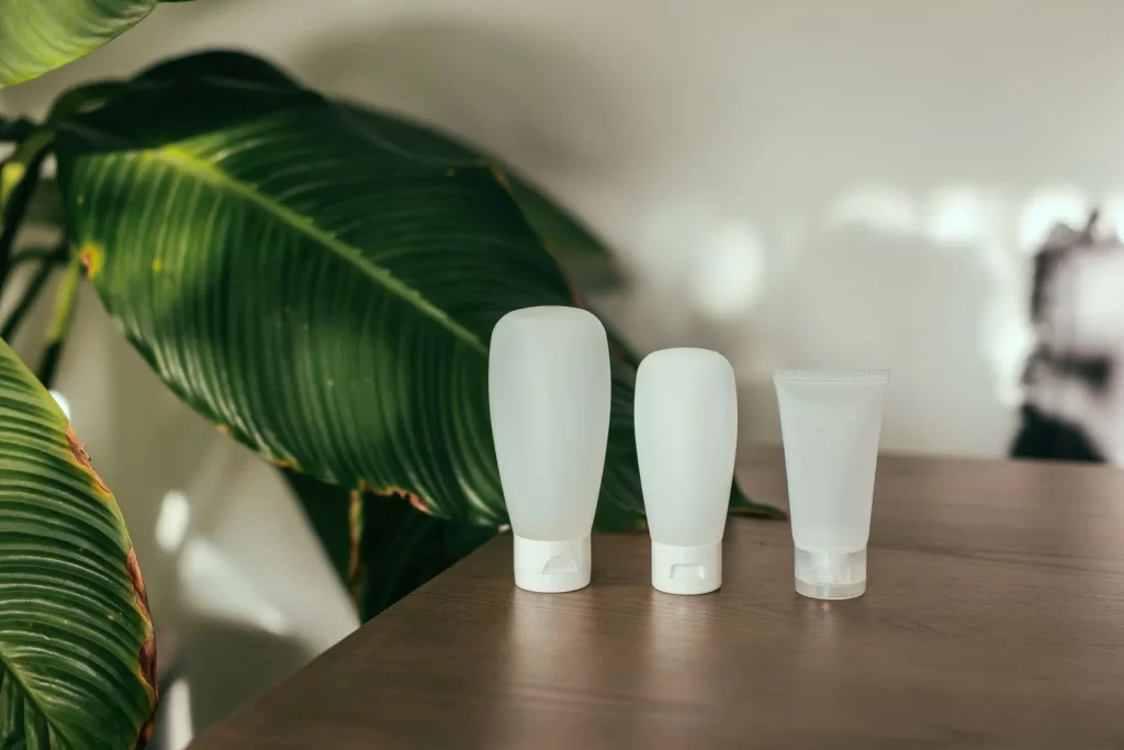 木桌上的简约化妆品瓶,绿叶背景