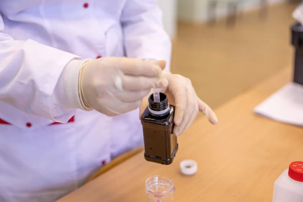 戴防护装备的科学家在实验室提取液体样本
