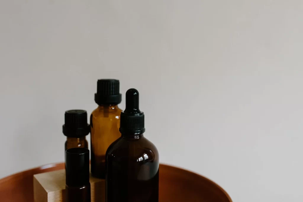 木托盘上摆放的琥珀色精油滴管瓶