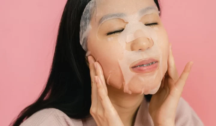 亚洲女性敷补水面膜,粉色背景