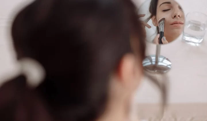 女性用刷子对镜补妆特写