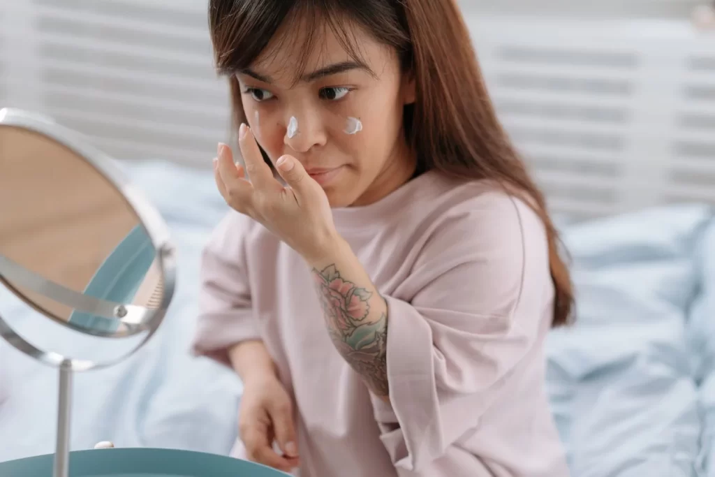 女性在卧室涂抹面霜,晨间护肤