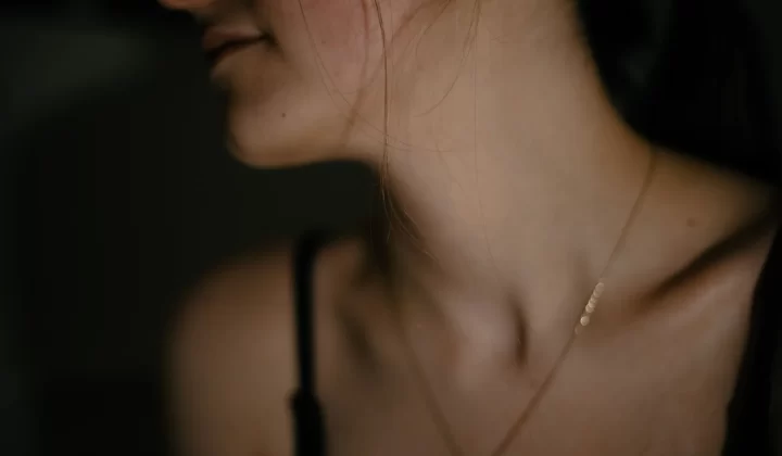 女性颈部特写,佩戴精致项链