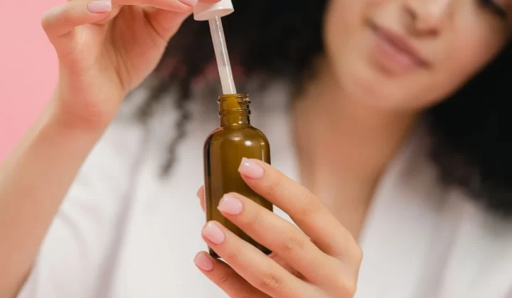 女性手持滴管瓶护肤特写