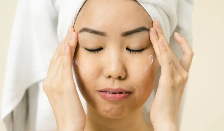 亚洲女性头裹毛巾涂抹保湿霜