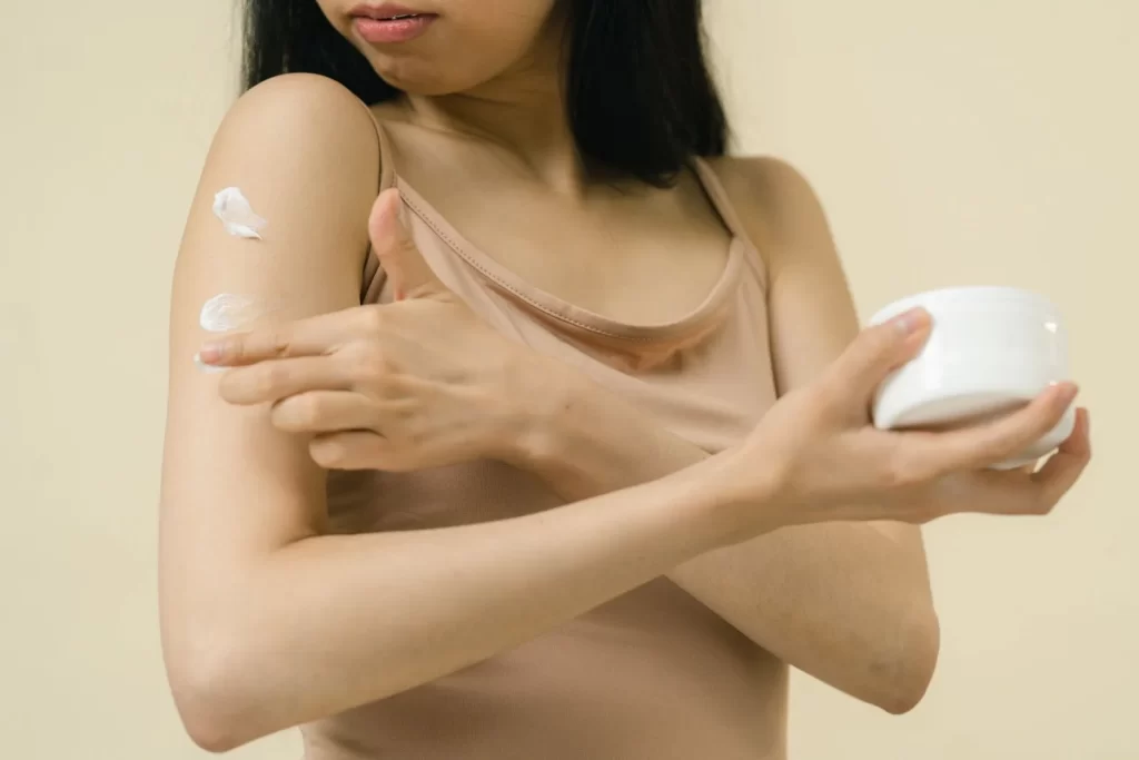 女性在手臂涂抹保湿霜特写