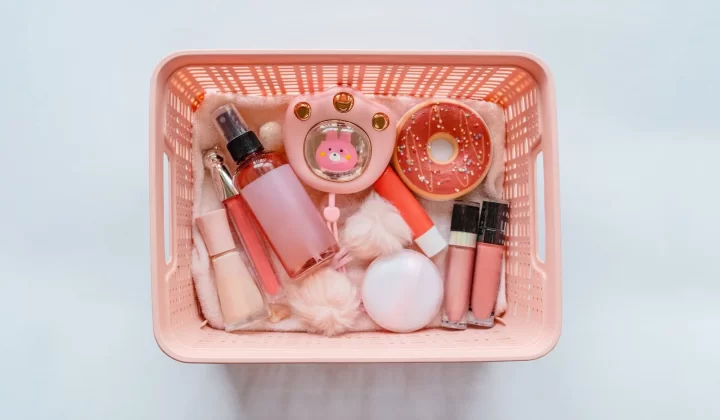 粉色篮子中整理的化妆品平铺