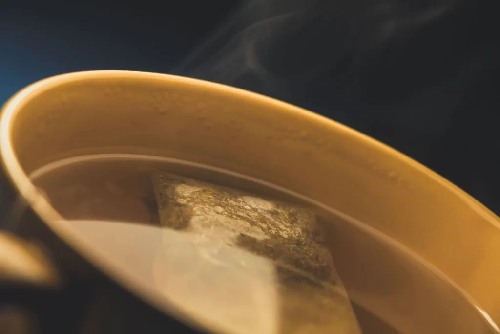冒着热气的茶杯特写,可见茶包