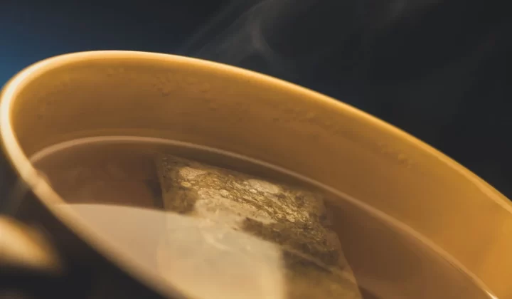 冒着热气的茶杯特写,可见茶包