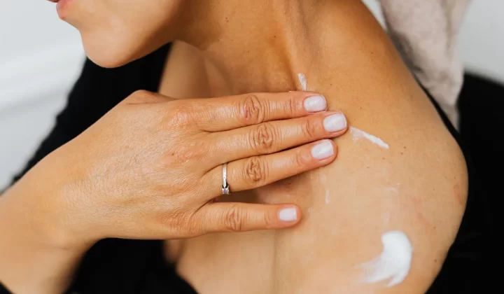 女性双手涂抹护肤乳于颈部