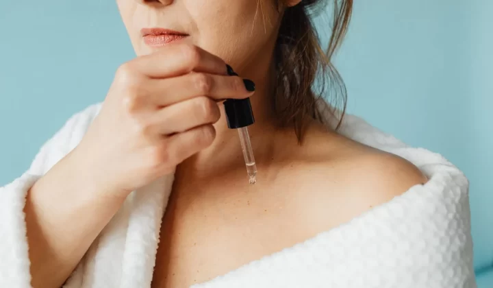 女性穿浴袍涂抹精华护肤特写