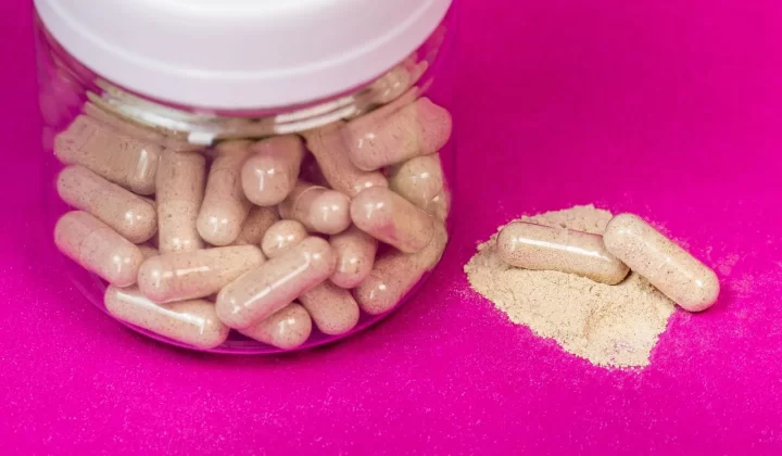 粉色背景上的胶囊玻璃罐特写
