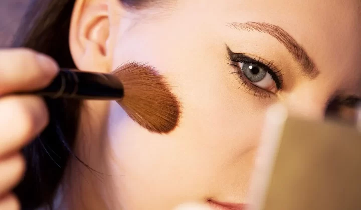 女性用刷子涂抹化妆品特写