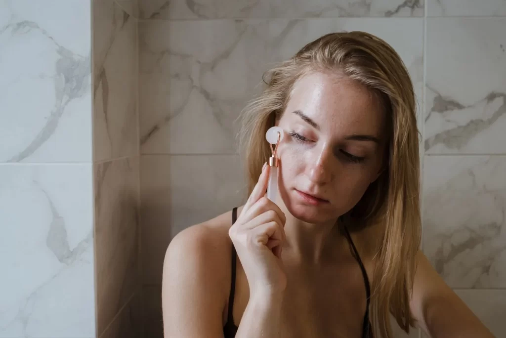 女性使用玉石滚轮按摩面部护肤