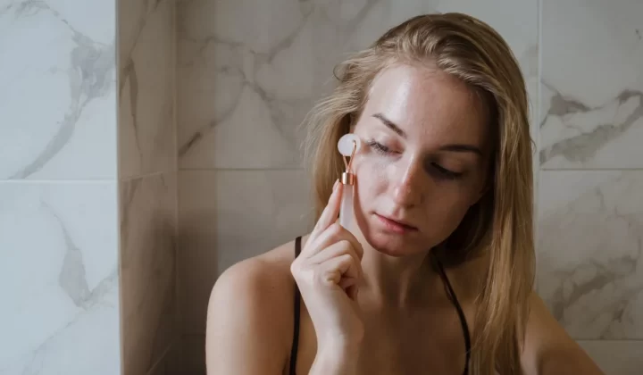 女性使用玉石滚轮按摩面部护肤