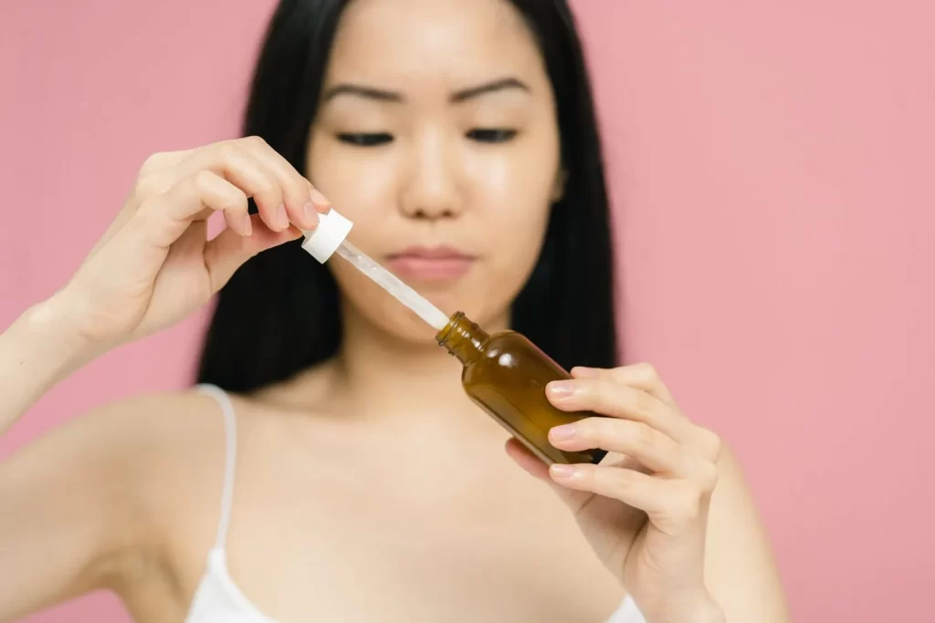 女性手持滴管精华瓶特写