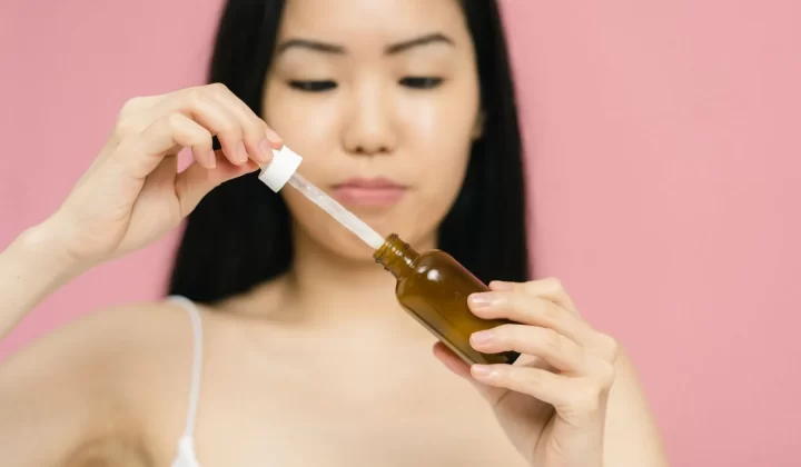 女性手持滴管精华瓶特写