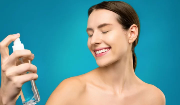 女性使用喷雾护肤,蓝色背景