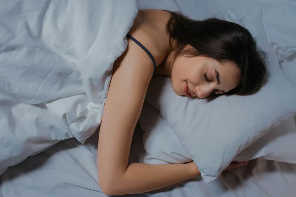 女性在舒适床上安睡,白色床品