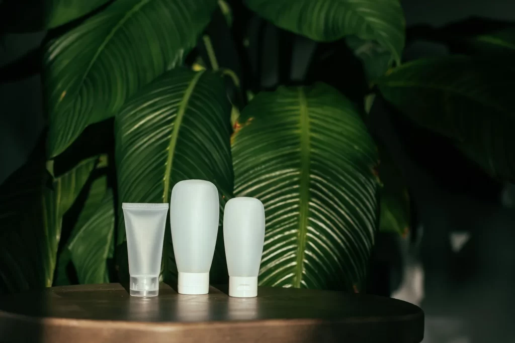 白色化妆品容器搭配绿叶背景