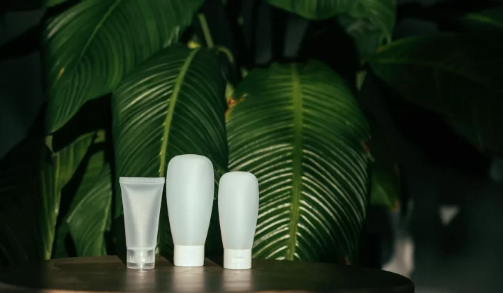 白色化妆品容器搭配绿叶背景