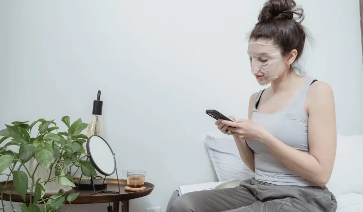 女性敷面膜使用手机放松居家场景