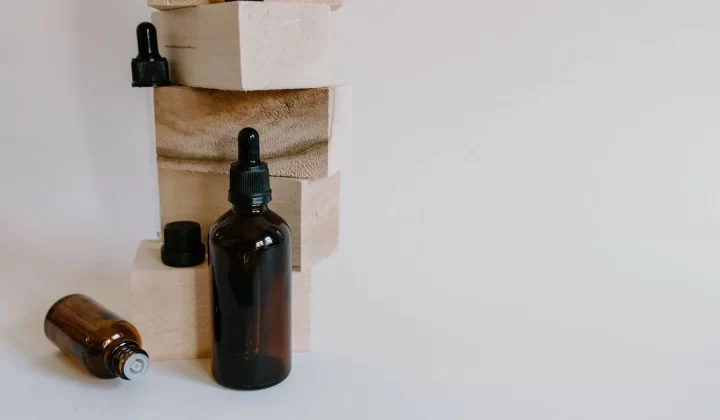 棕色精油滴管瓶靠在木块旁,极简风格