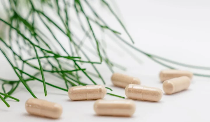 天然草本补充剂胶囊搭配绿叶特写