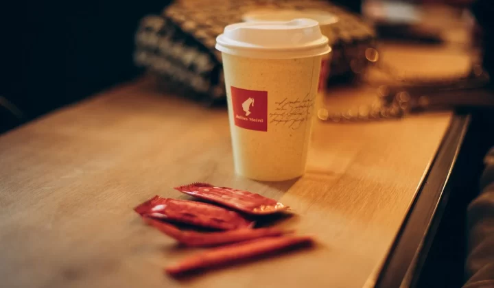咖啡杯搭配糖包放在质朴木桌上