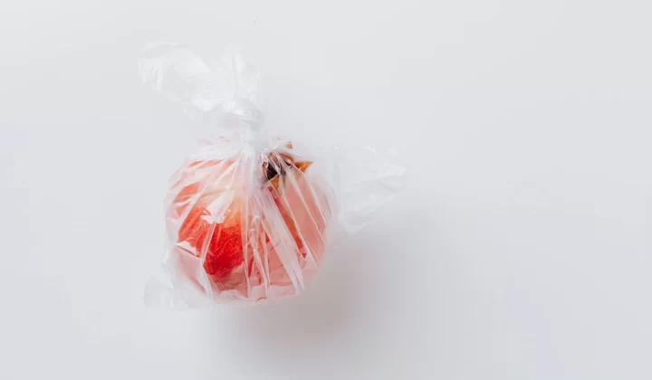 石榴用透明塑料袋包裹,白色背景极简风格