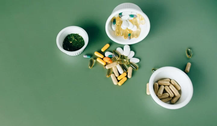 多种草本和维生素药丸胶囊放在绿色表面