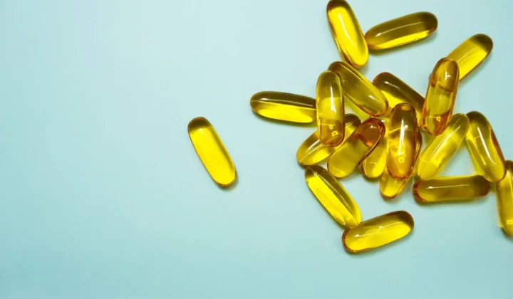 Omega-3胶囊摆放在浅蓝色表面特写