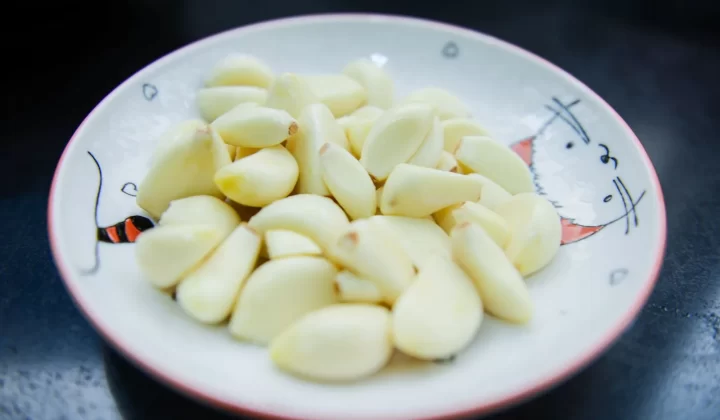去皮大蒜瓣摆放在装饰盘上特写,展现新鲜质感