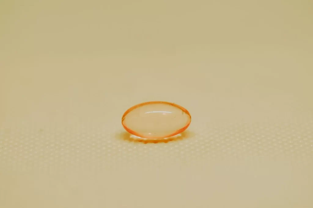 单颗橙色药用胶囊放在纹理表面特写