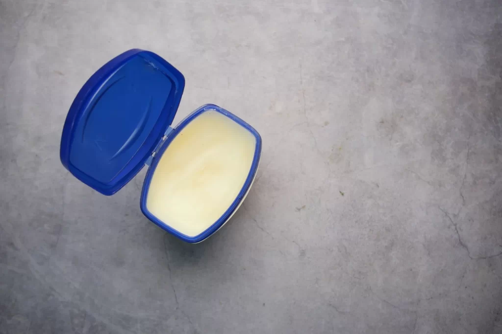 打开的蓝色塑料容器装有乳霜状物质,灰色背景