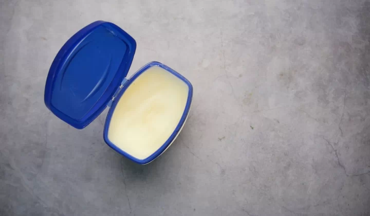 打开的蓝色塑料容器装有乳霜状物质,灰色背景