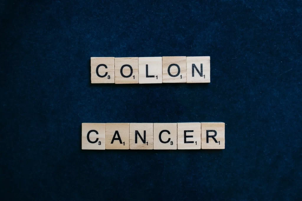 木质字母拼字块拼出"Colon Cancer"字样,蓝色背景