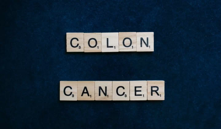 木质字母拼字块拼出"Colon Cancer"字样,蓝色背景