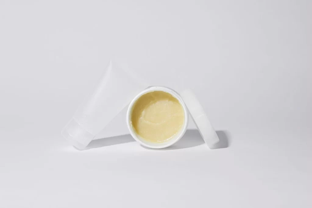 白色塑料容器装黄色乳霜产品,白色背景棚拍