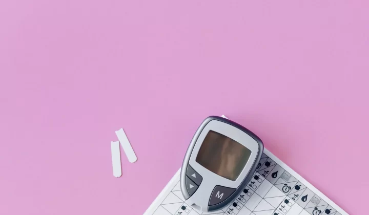 血糖仪和试纸平铺放在粉色表面