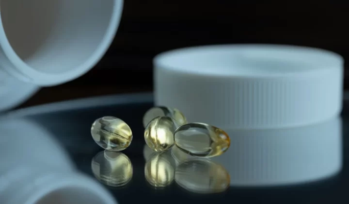 凝胶胶囊搭配白色瓶盖特写,健康补充剂主题
