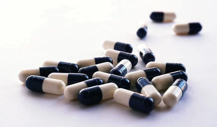 各种胶囊散落在白色表面,医疗保健主题