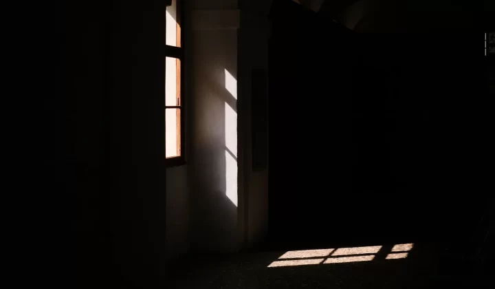 昏暗房间中阳光透过窗户洒入,形成戏剧性阴影