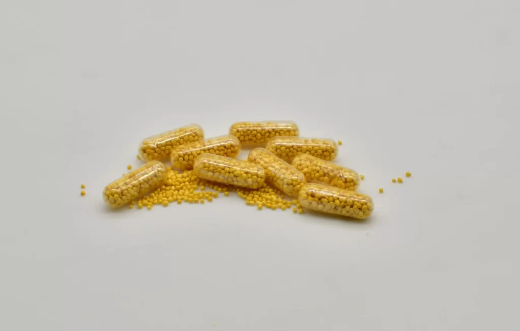 黄色胶囊散落在白色表面,象征健康和药物