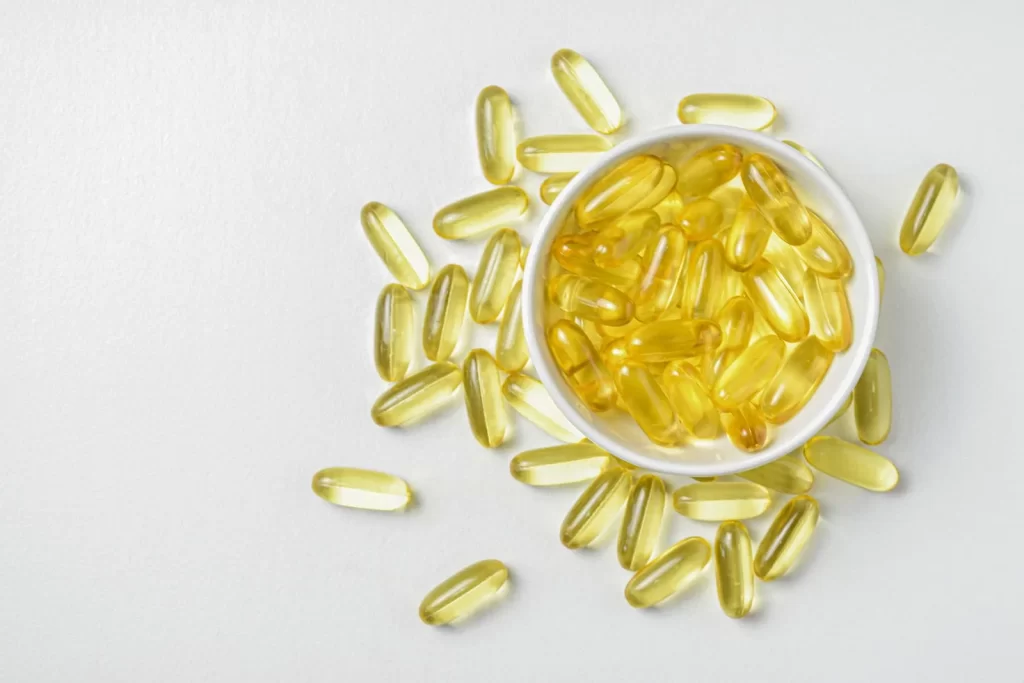 陶瓷碗中的Omega-3鱼油胶囊高角度特写,白色背景